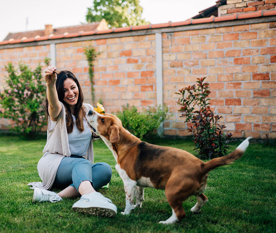 Woman playing in backyard with her dog.