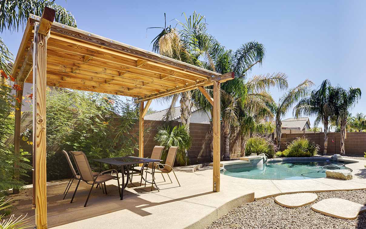 Wooden gazebo and pool in backyard