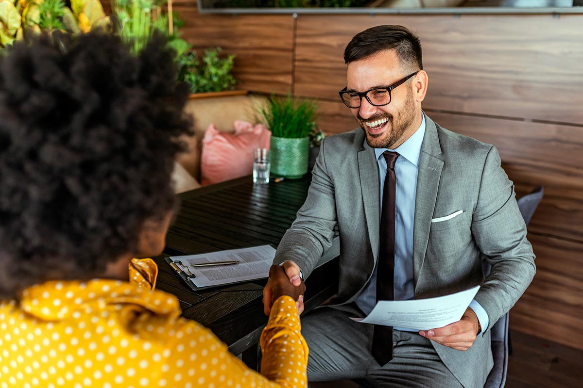 Business woman and smiling man shaking hands