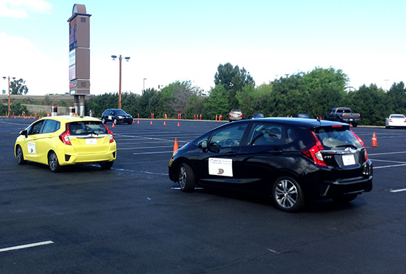 Two vehicles practicing safe driving in a parking lot