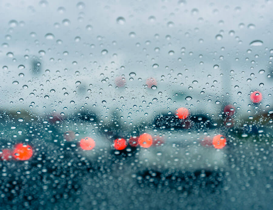 Driving in the rain looking through water spotted windshield.